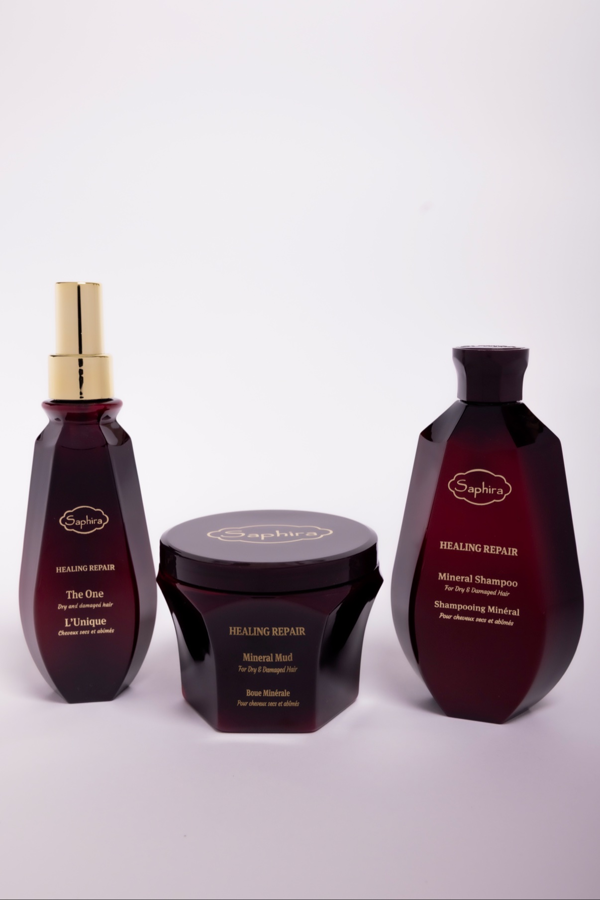 Saphira Healing Repair hair-care trio of burgundy bottles on white