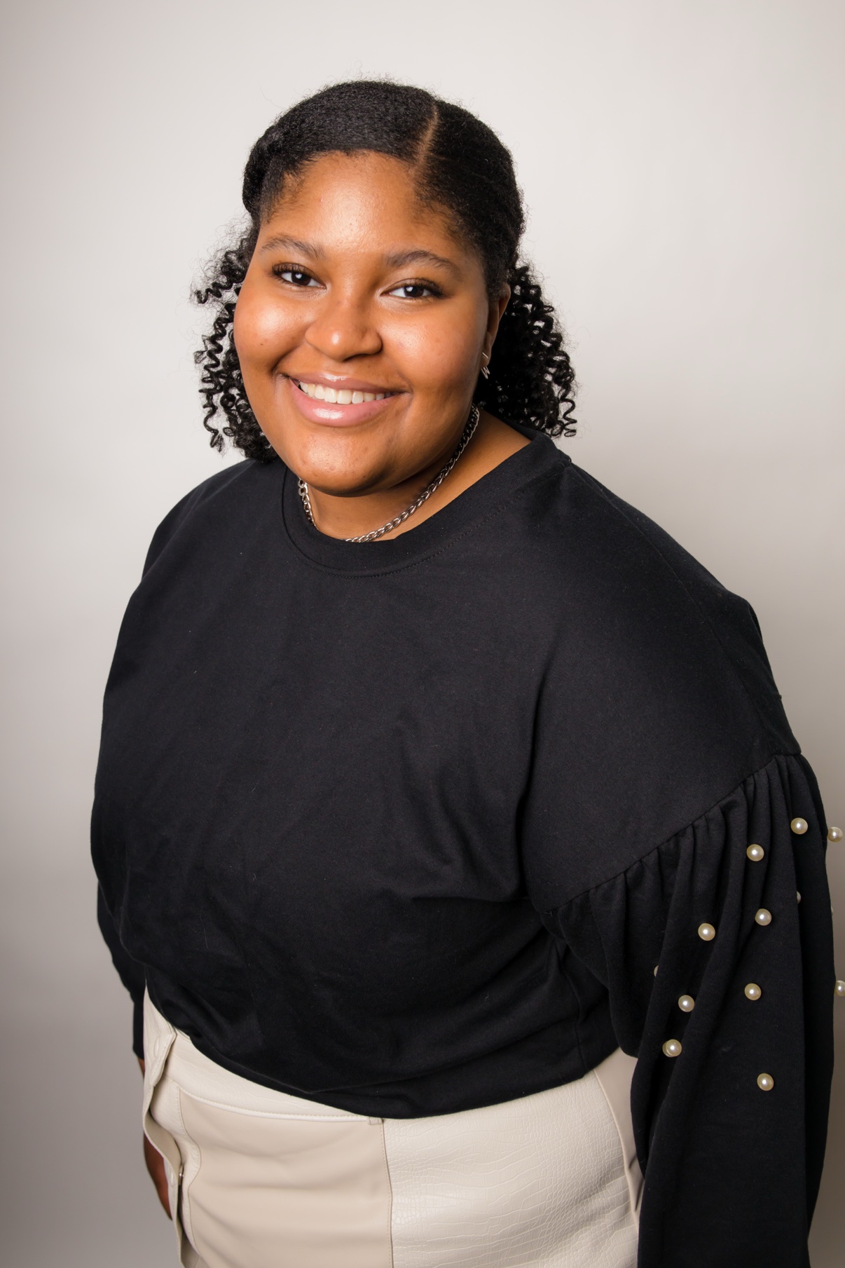Smiling woman in a black pearled-sleeve top