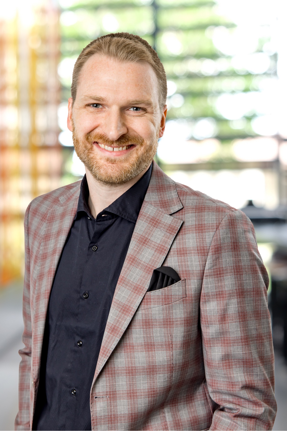 Smiling man in a plaid blazer with a pocket square