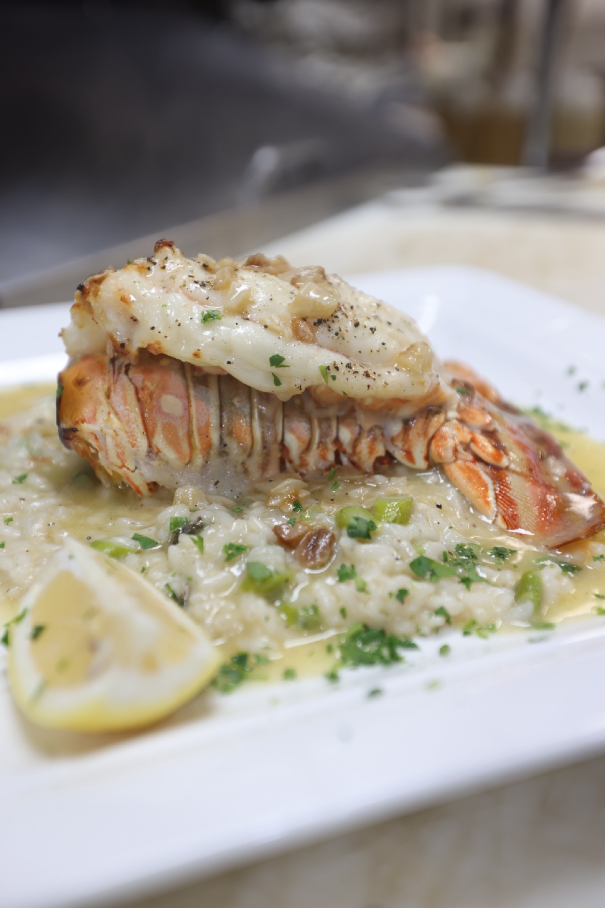 Lobster tail over risotto with a lemon wedge