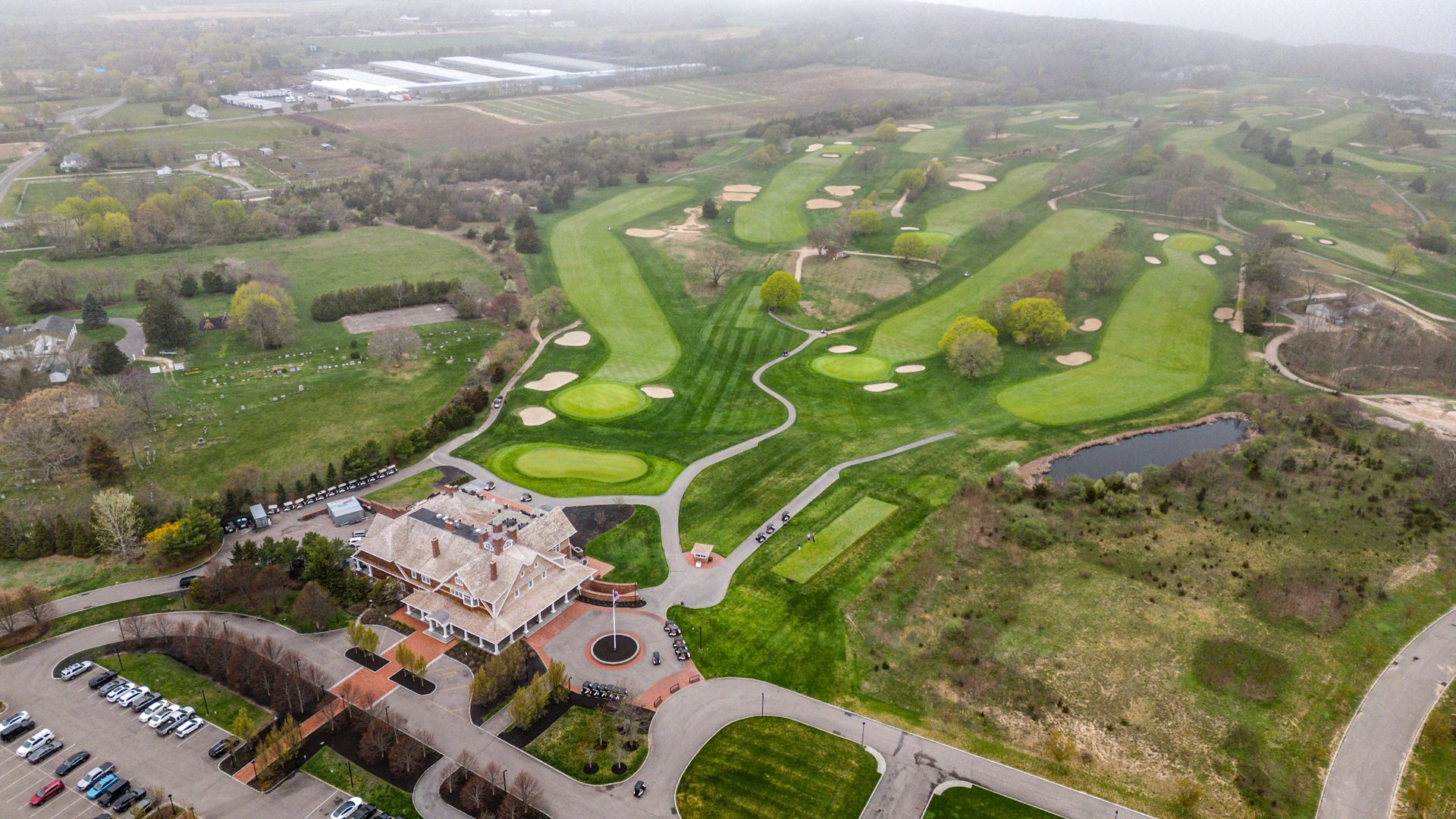 Aerial drone view of an estate home with swimming pool
