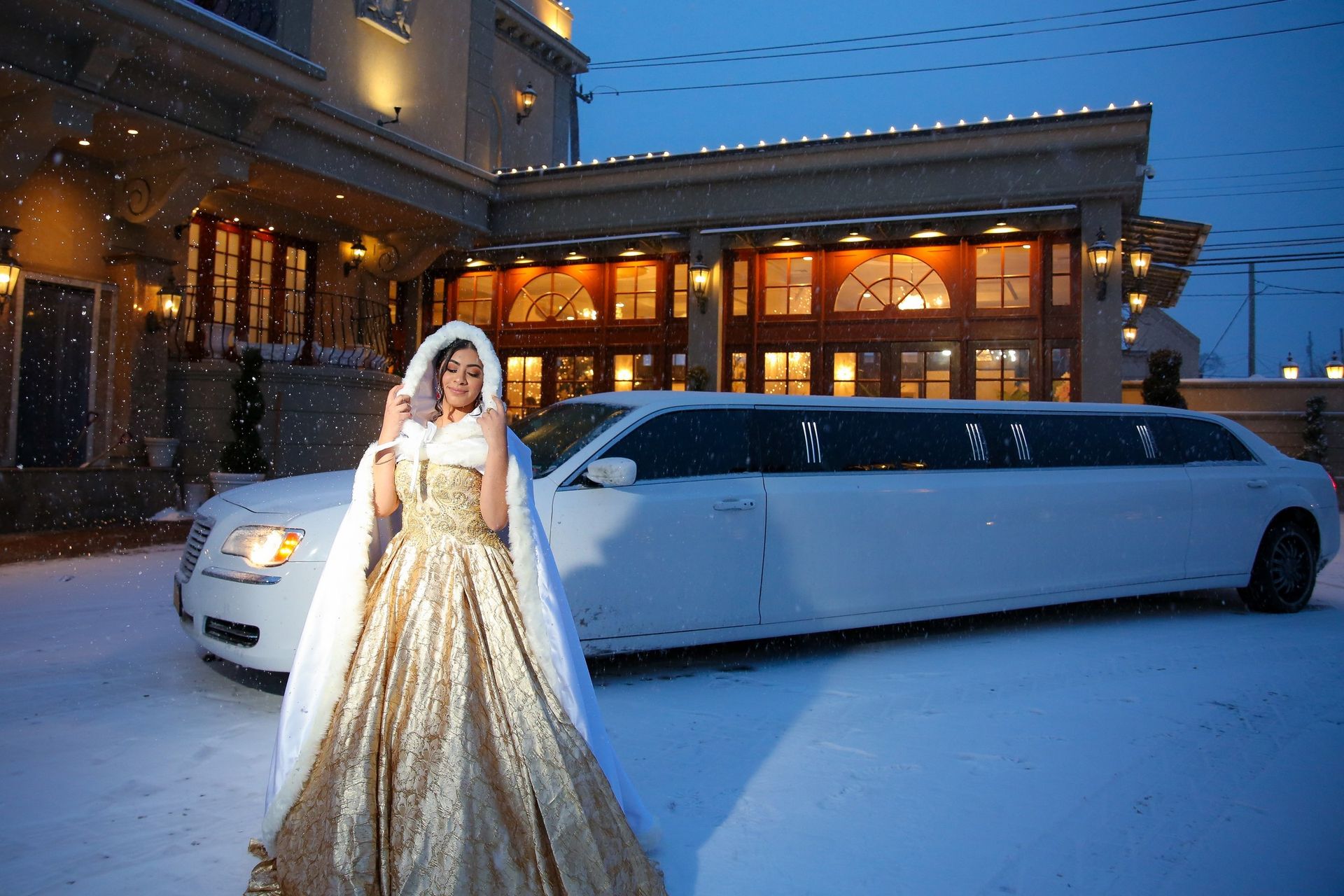 Quinceañera in a gold gown beside a white limousine in the snow
