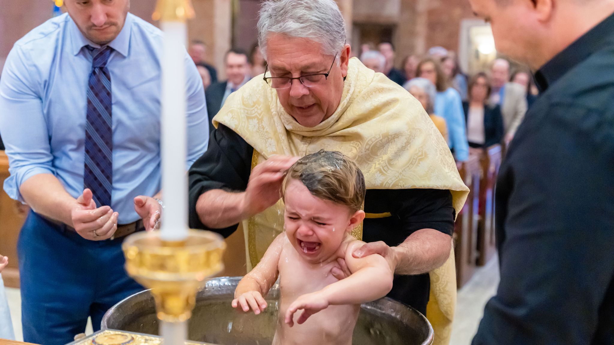 Baby being baptized with water