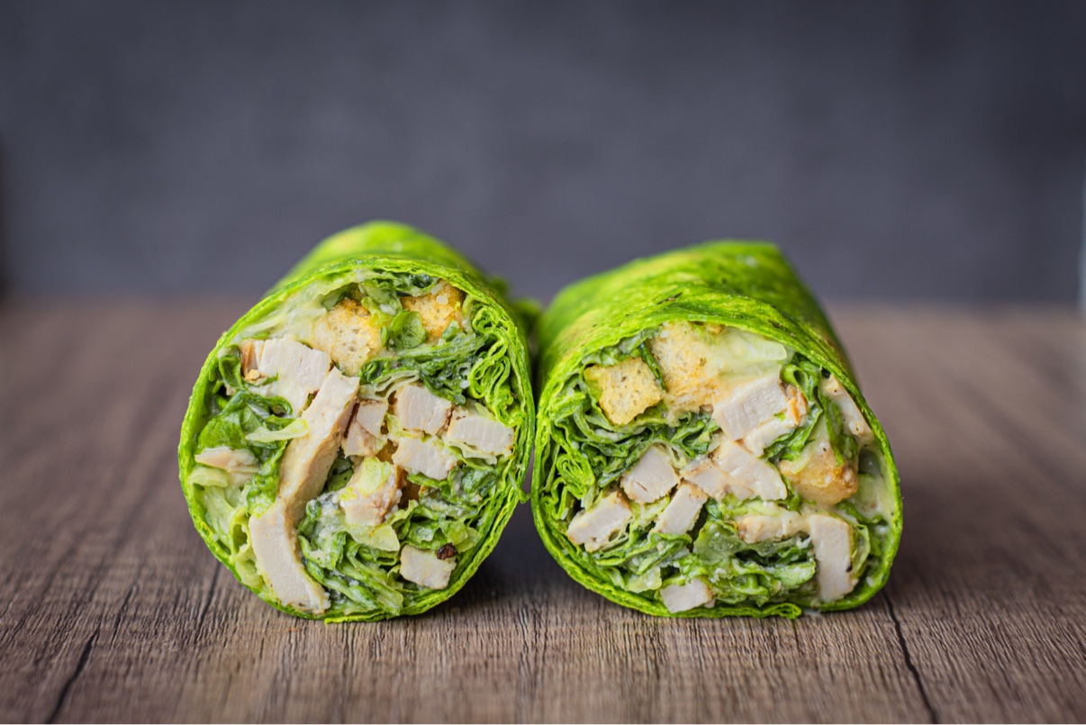 Chicken caesar wraps cut in half in green tortillas