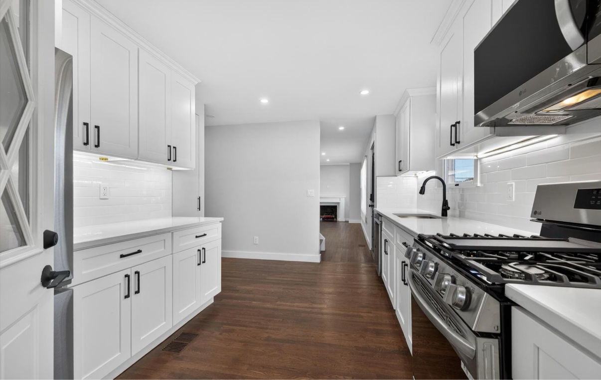 Galley kitchen with white shaker cabinets and stainless steel appliances