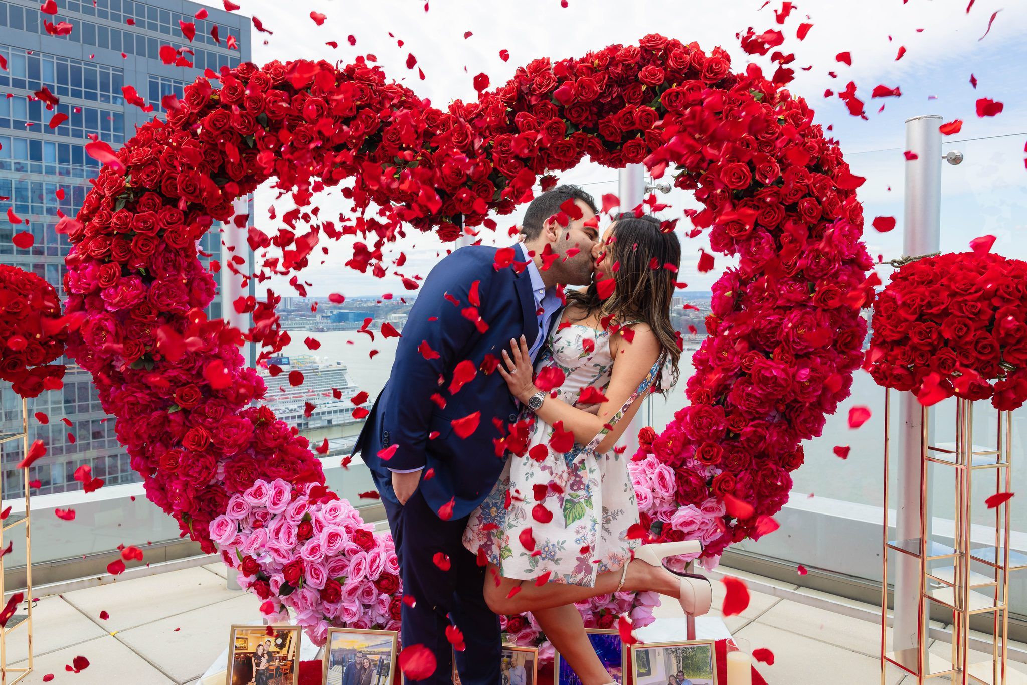 Kiss under a red rose heart arch